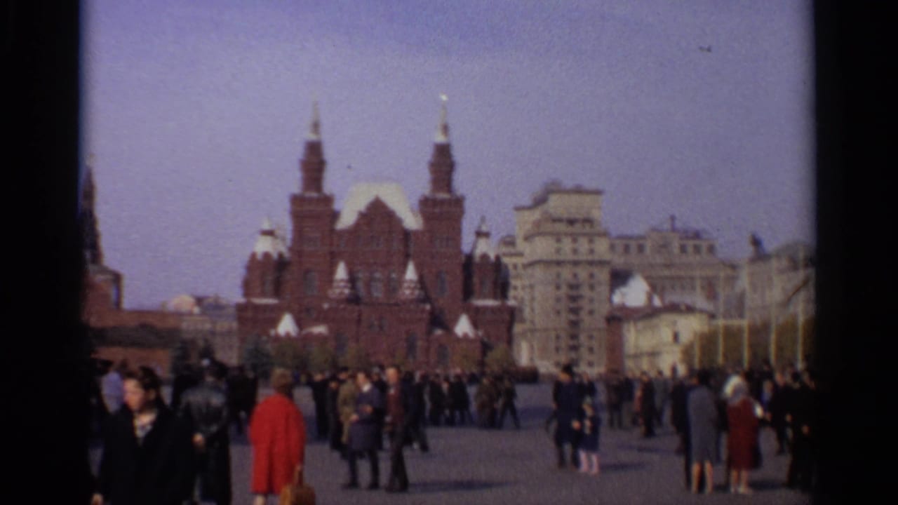 Crowds cross Red Square with a red brick landmark and pale buildings beyond.