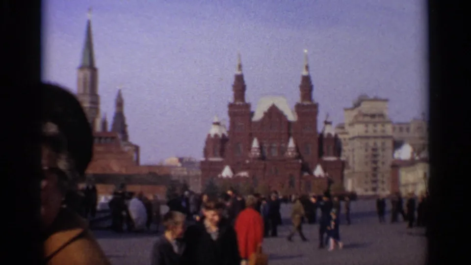 1965 Moscow crowd scene in Red Square, with a close foreground face and major public buildings beyond.