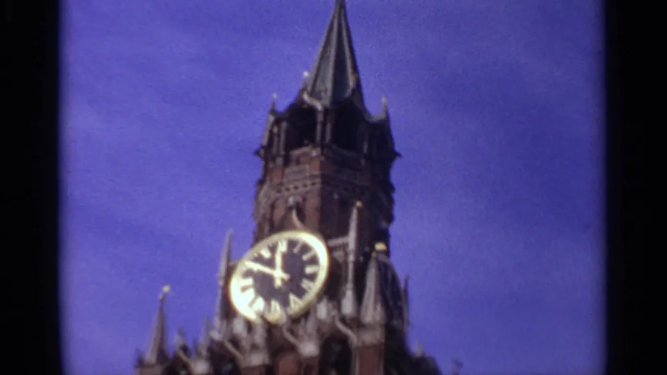 1965 Moscow frame showing the Spasskaya Tower clock, pointed roof and upper brickwork against blue sky.