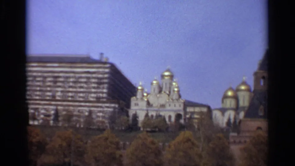 1965 Moscow frame showing golden onion domes and the State Kremlin Palace, with soft 8mm color and dark frame edges.