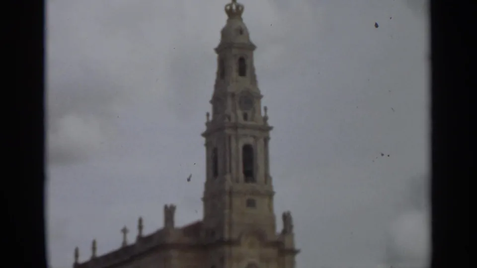1965 Nazaré church exterior with the bell tower and upper facade visible between dark home-movie frame borders.