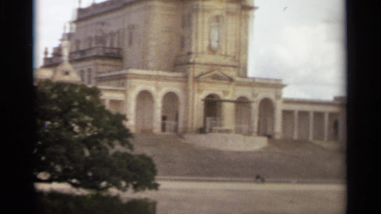 1965 Nazare, Portugal view of the ornate facade, arched portico, tower, and broad steps.