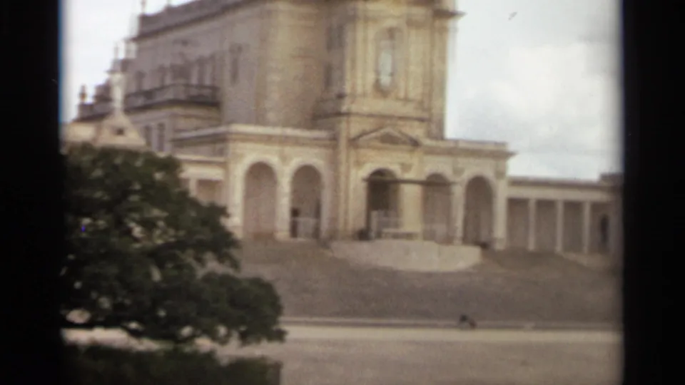 1965 Nazare, Portugal view of the ornate facade, arched portico, tower, and broad steps.