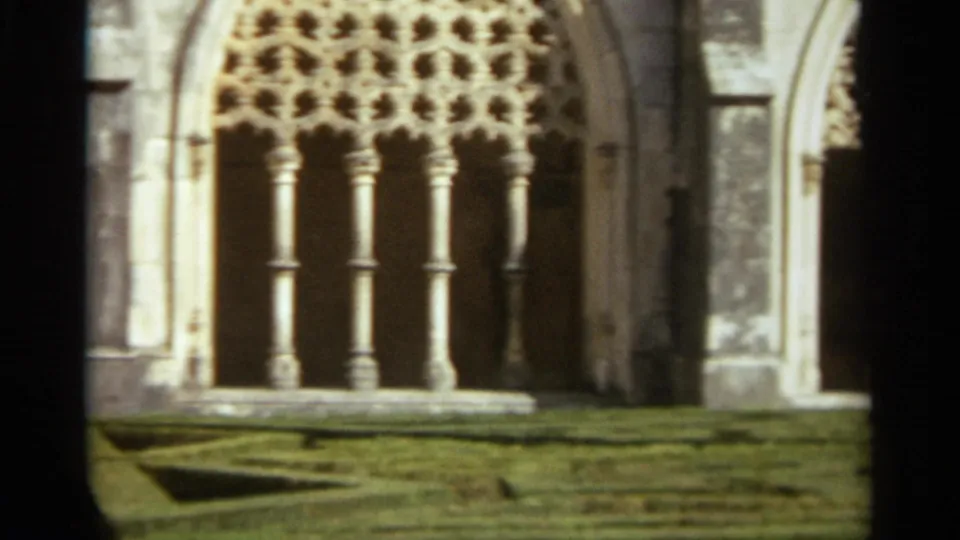 1965 Nazaré, Portugal frame focusing on carved arcade tracery and columns in a historic religious courtyard.