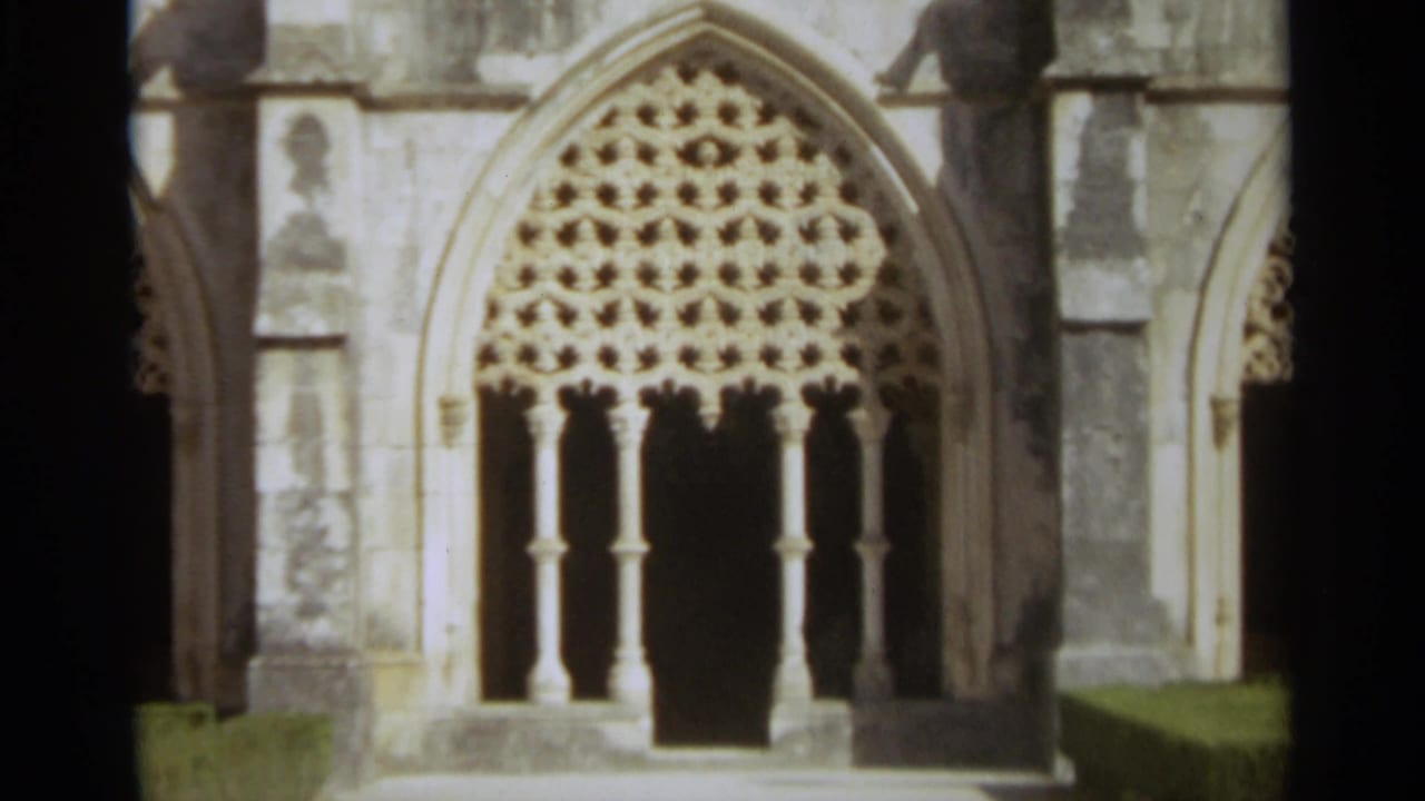 Close view of an ornate pointed arch church window with stone tracery and slender columns.