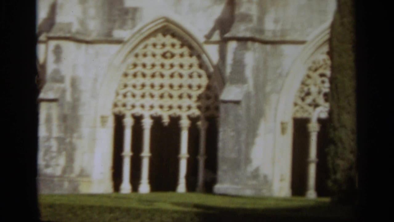 Large arched church window with dense tracery set in pale weathered stone.