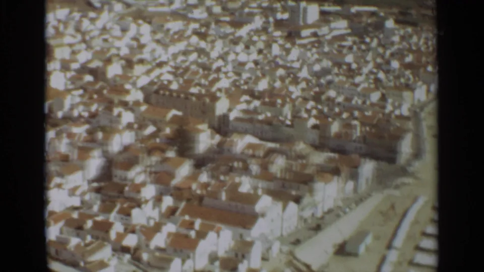 Final aerial frame over Nazare with dense white housing, terracotta roofs, and a pale road or edge feature at lower right.