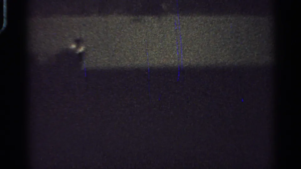 1965 Saint Louis 8mm frame showing a distant dark horse-and-rider silhouette against a faint horizontal band.