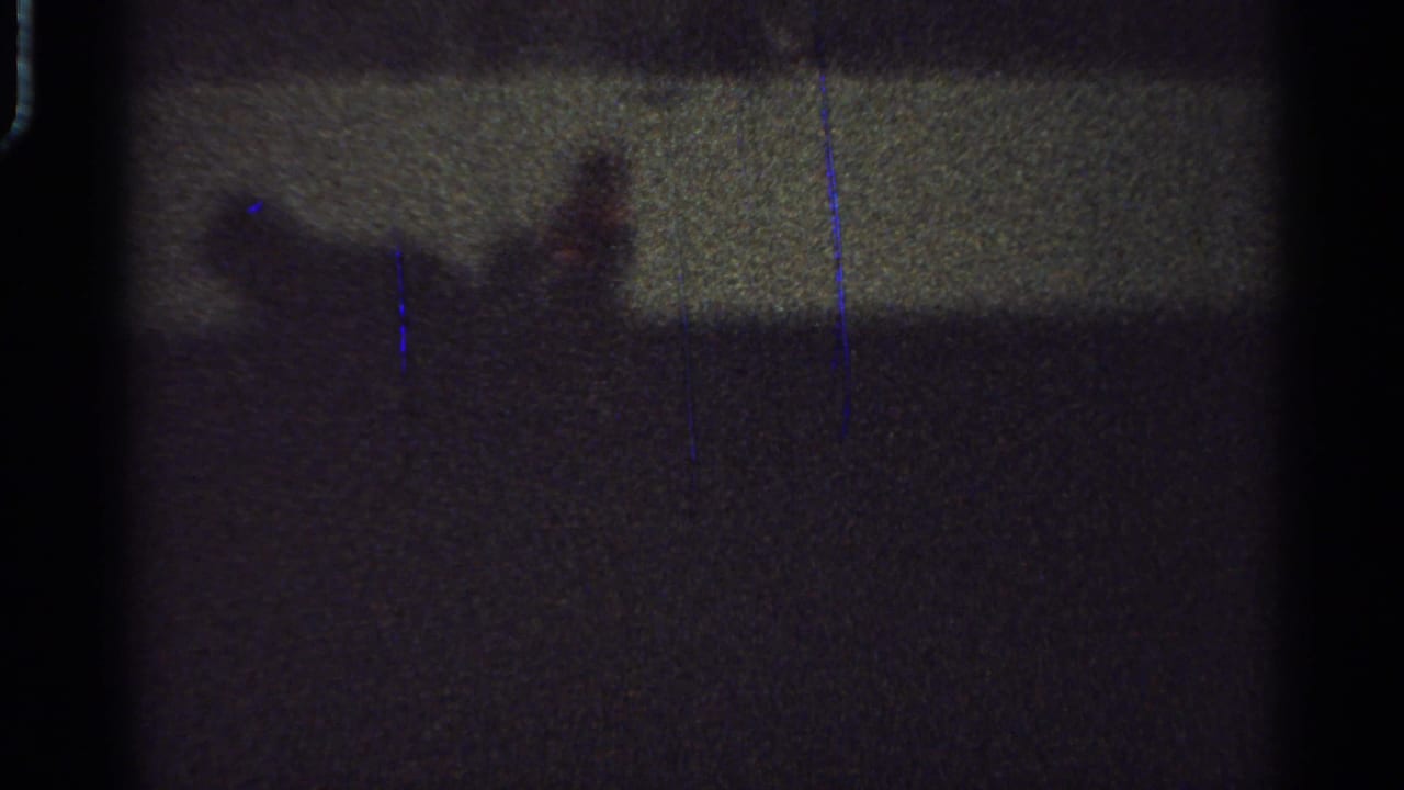 Low-light 1965 Saint Louis frame with the rider and horse reduced to a blurred silhouette near the horizon line.