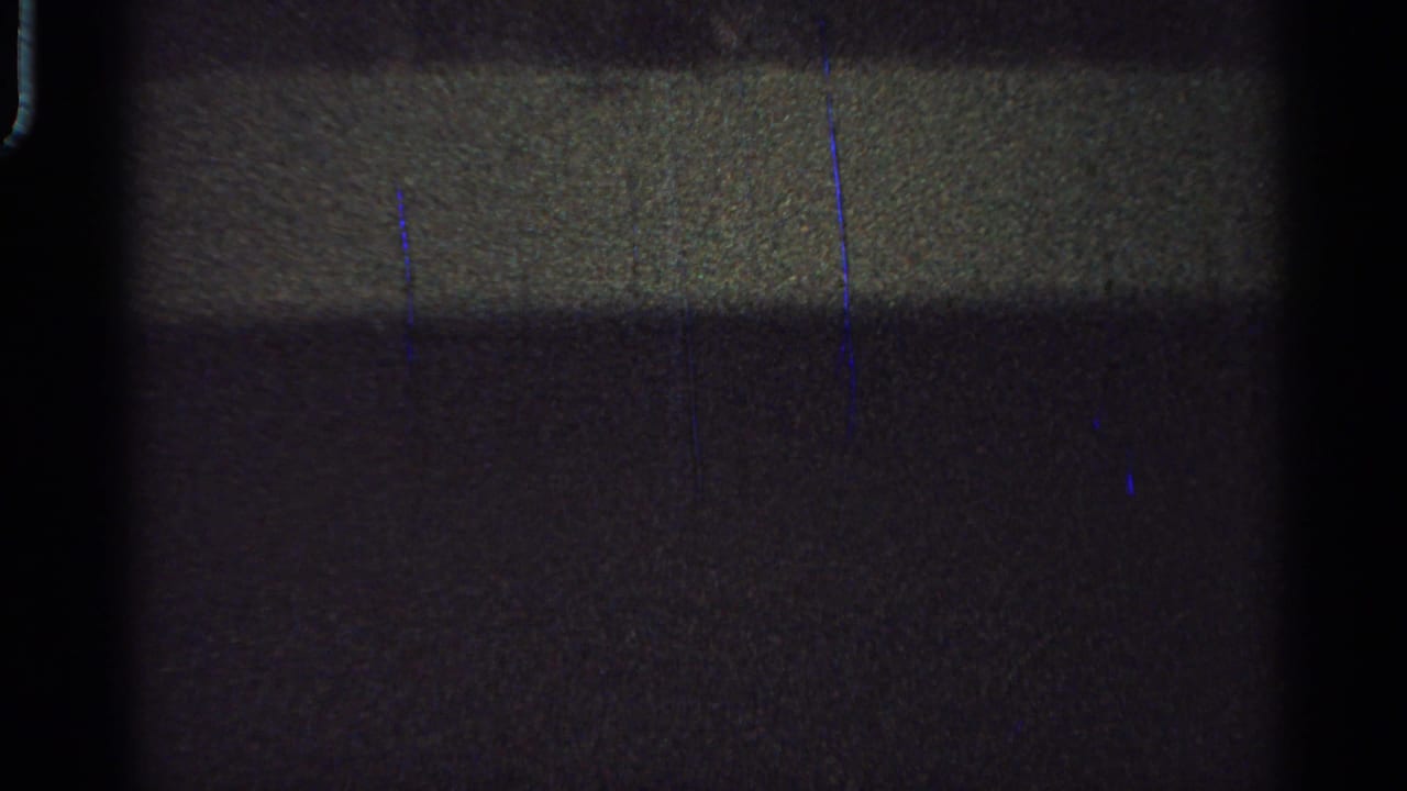 Grainy 8mm frame from the Saint Louis clip where the horse and rider are difficult to distinguish in darkness.