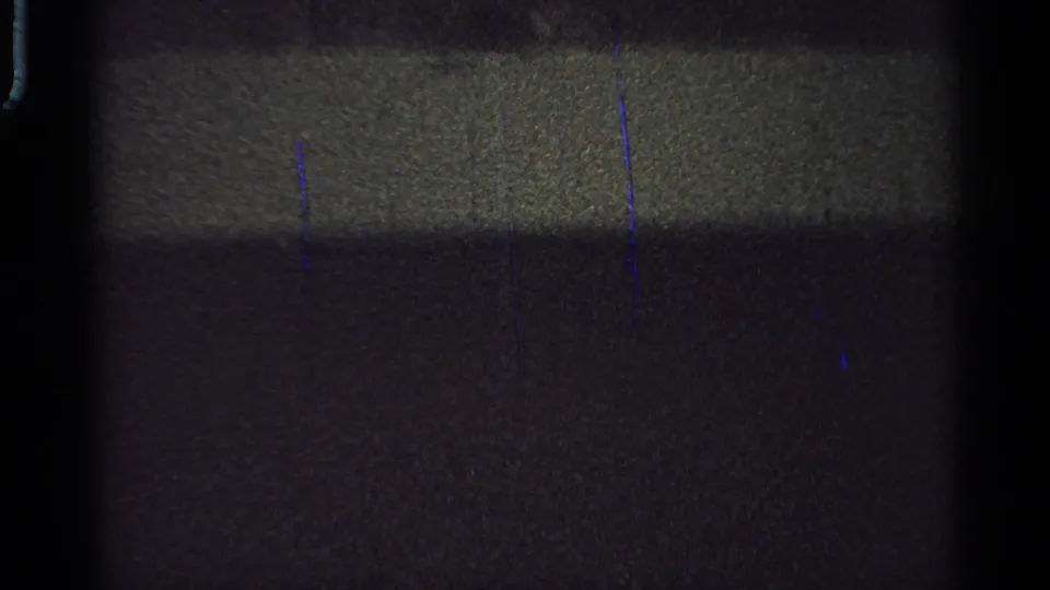 Grainy 8mm frame from the Saint Louis clip where the horse and rider are difficult to distinguish in darkness.