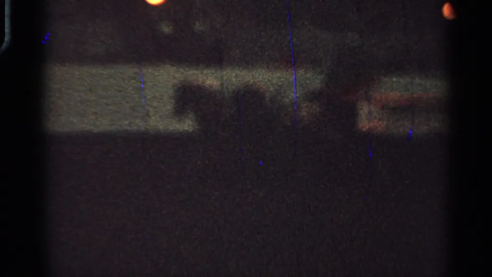 Low-light 1965 Saint Louis 8mm frame with a barely visible horse-drawn carriage area and soft street lights.
