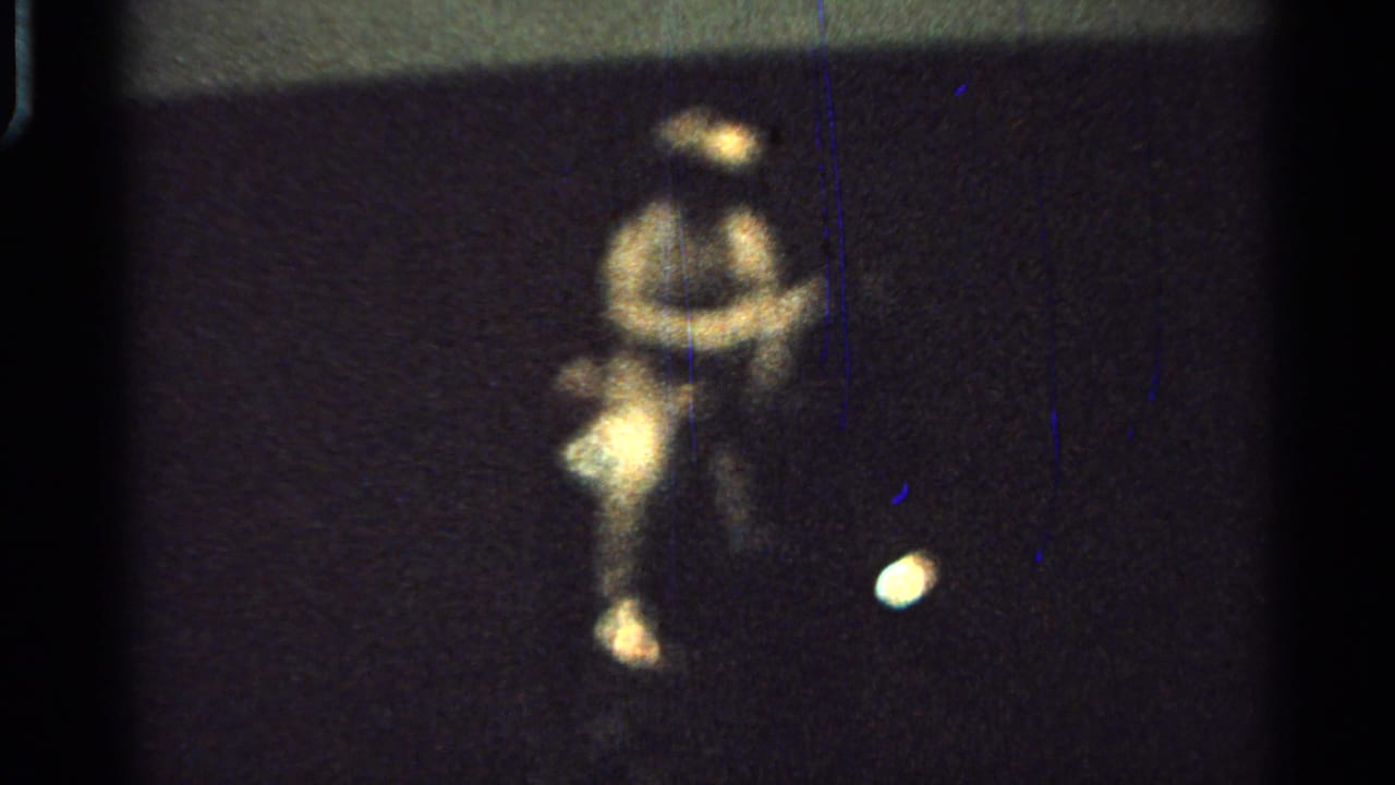 Blurred seated person in light clothing on a dark horse-drawn cart at night.