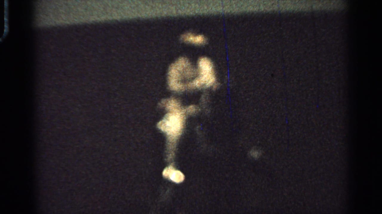 A blurry rider on a horse-drawn cart remains visible in the final 1965 Saint Louis frame, surrounded by darkness and film wear.