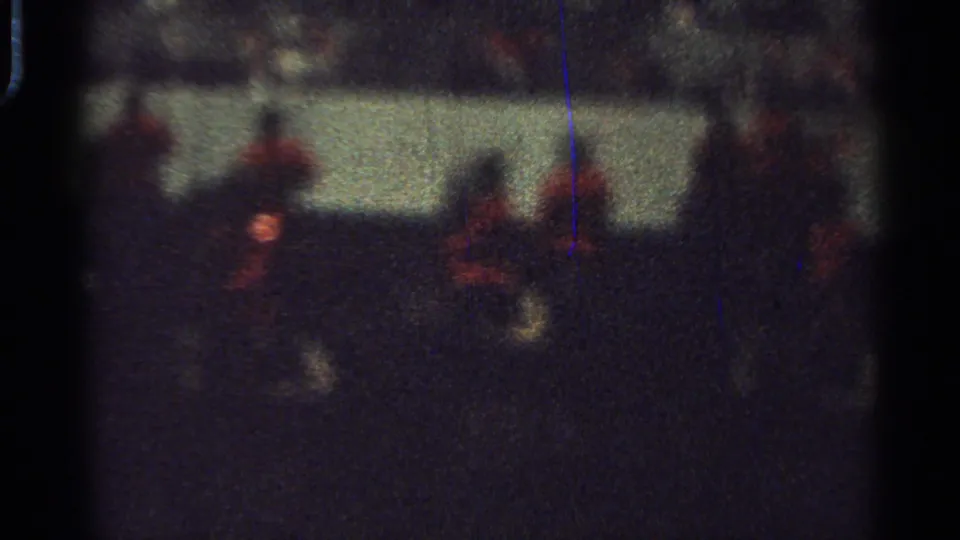 1965 Saint Louis 8mm frame showing blurred riders in red coats on dark horses during a nighttime parade.