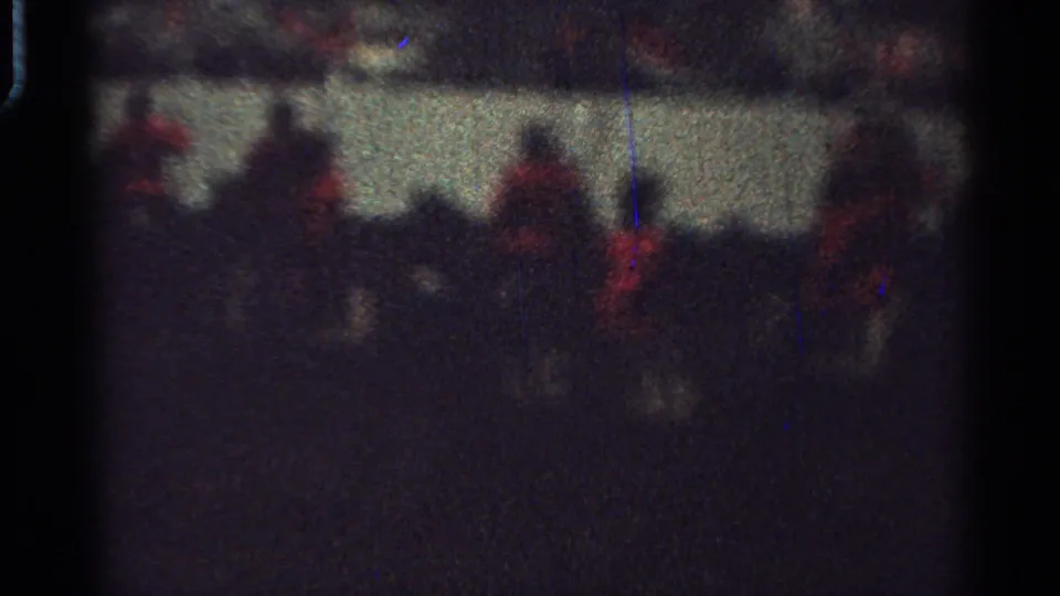 Low-light 8mm view of red-coated mounted riders crossing the frame in Saint Louis, Missouri, in 1965.