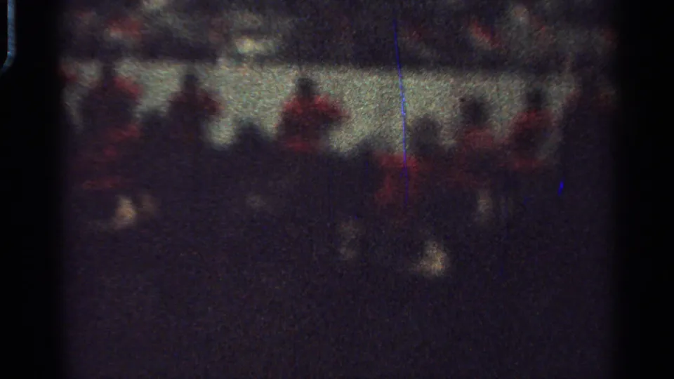 Saint Louis 1965 nighttime parade frame with blurred mounted riders, red coats, and possible flags or poles.