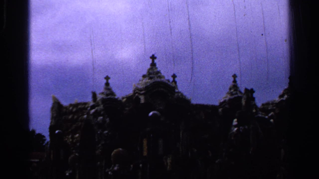 Dark silhouetted ornate spires and crosses against a purple-blue sky.