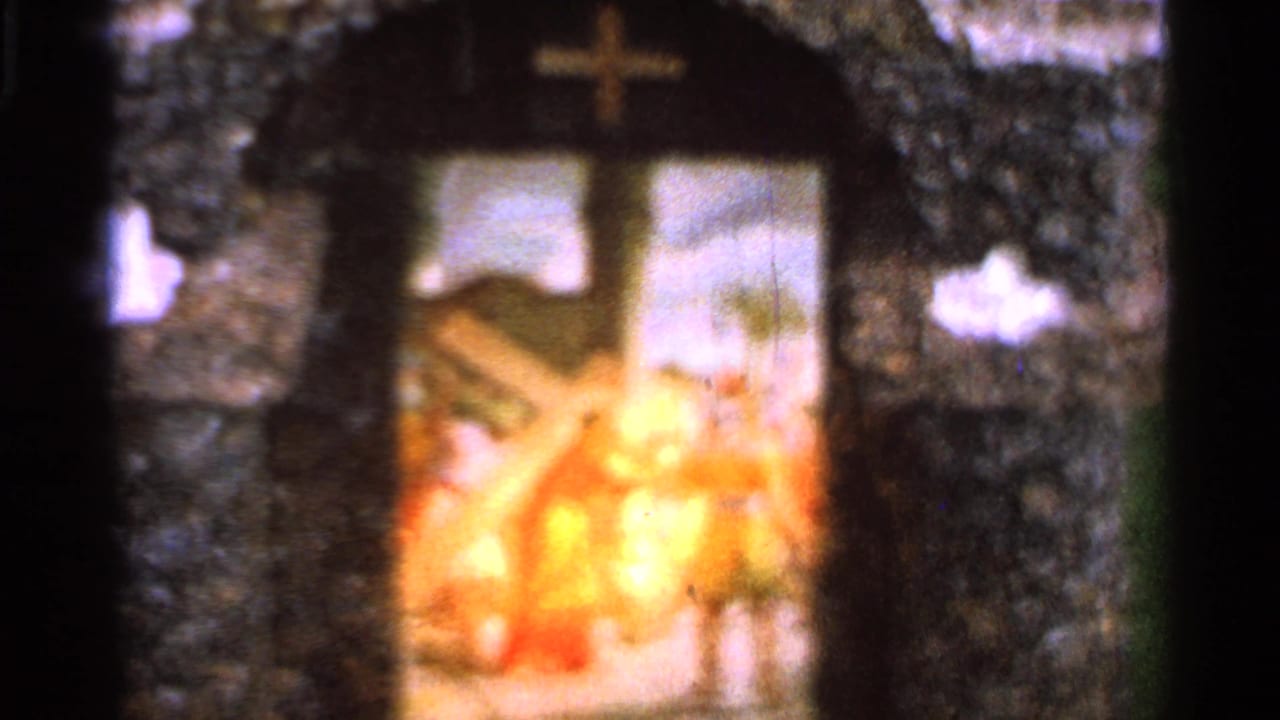 Stone archway with a cross above a bright religious painting.