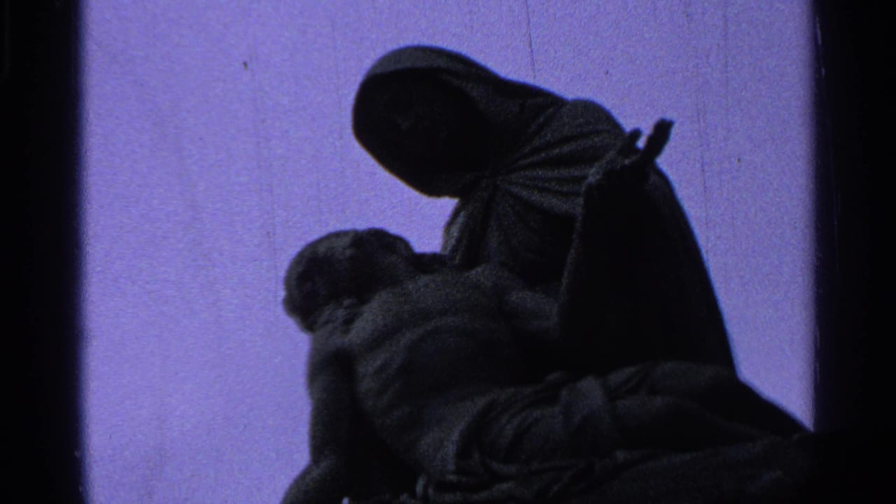 Purple-tinted 8mm frame of a dark Madonna and Christ statue silhouetted in an outdoor Saint Louis setting.