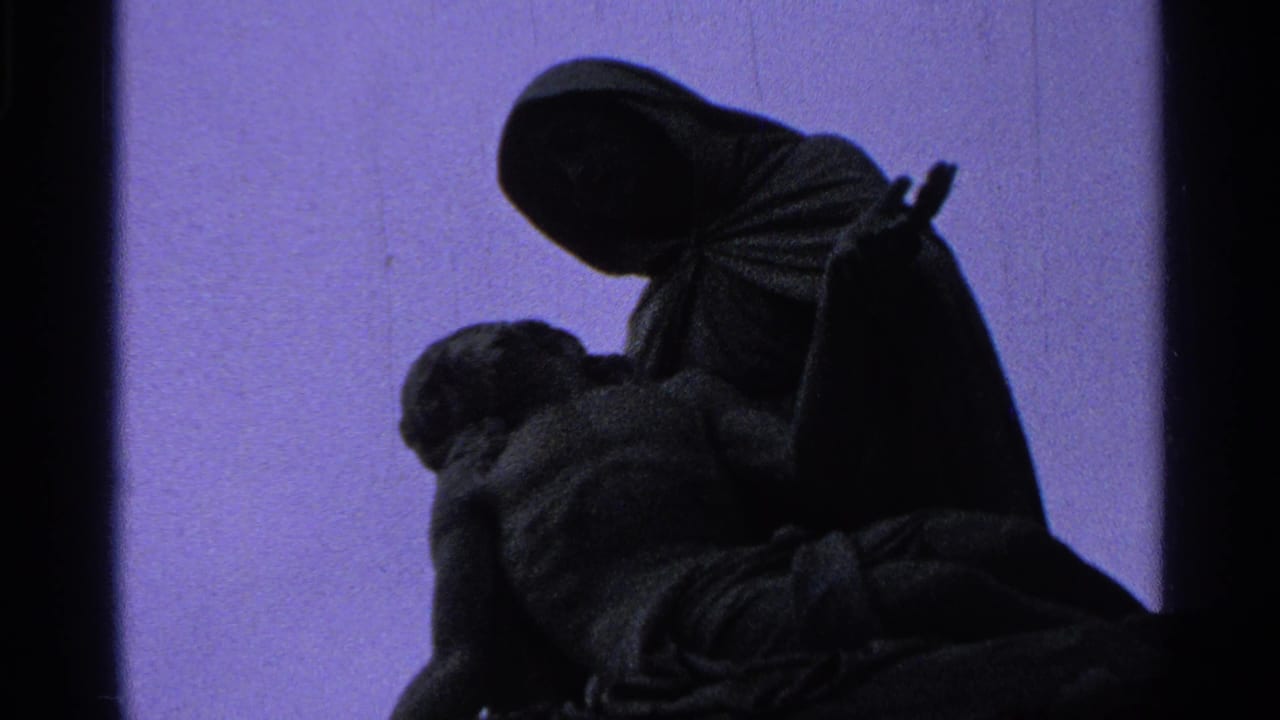 Close 1965 8mm view of the Madonna and Christ statue, with the figures mostly in shadow and purple color shift.