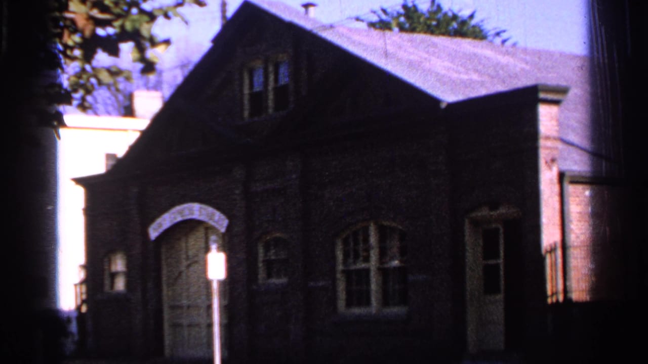 Dark brick Pony Express Stables facade with arched doors, windows, roofline, and street sign.