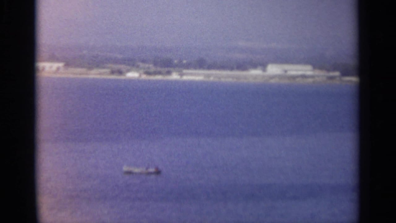 Distant shoreline across blue water with a small boat near the lower left.