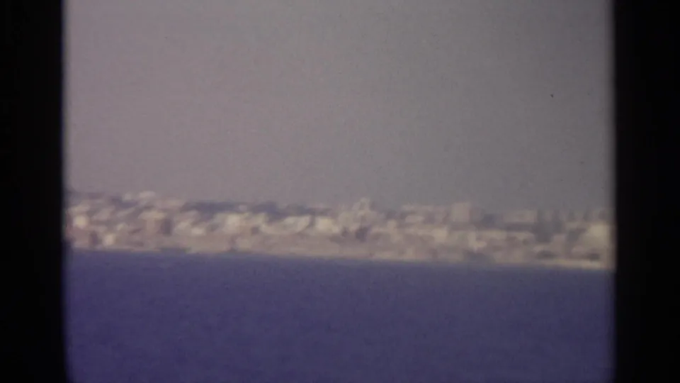 Lower contact-sheet frame shows a hazy coastal settlement across the water, consistent with the clip's 1965 Sicily travel metadata.