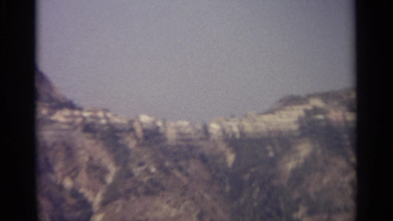 Mountain slopes and clustered pale buildings seen through soft focus.