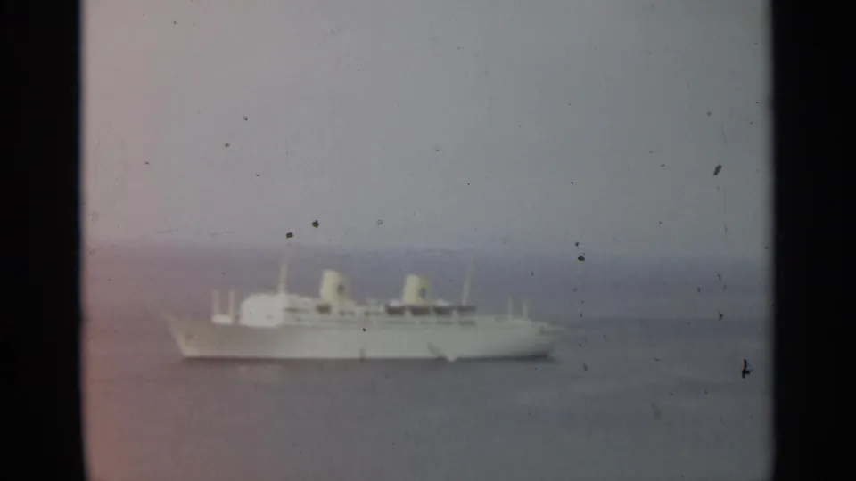 1965 8mm view near Stockholm showing a white passenger ship at sea beneath a muted, cloudy horizon.