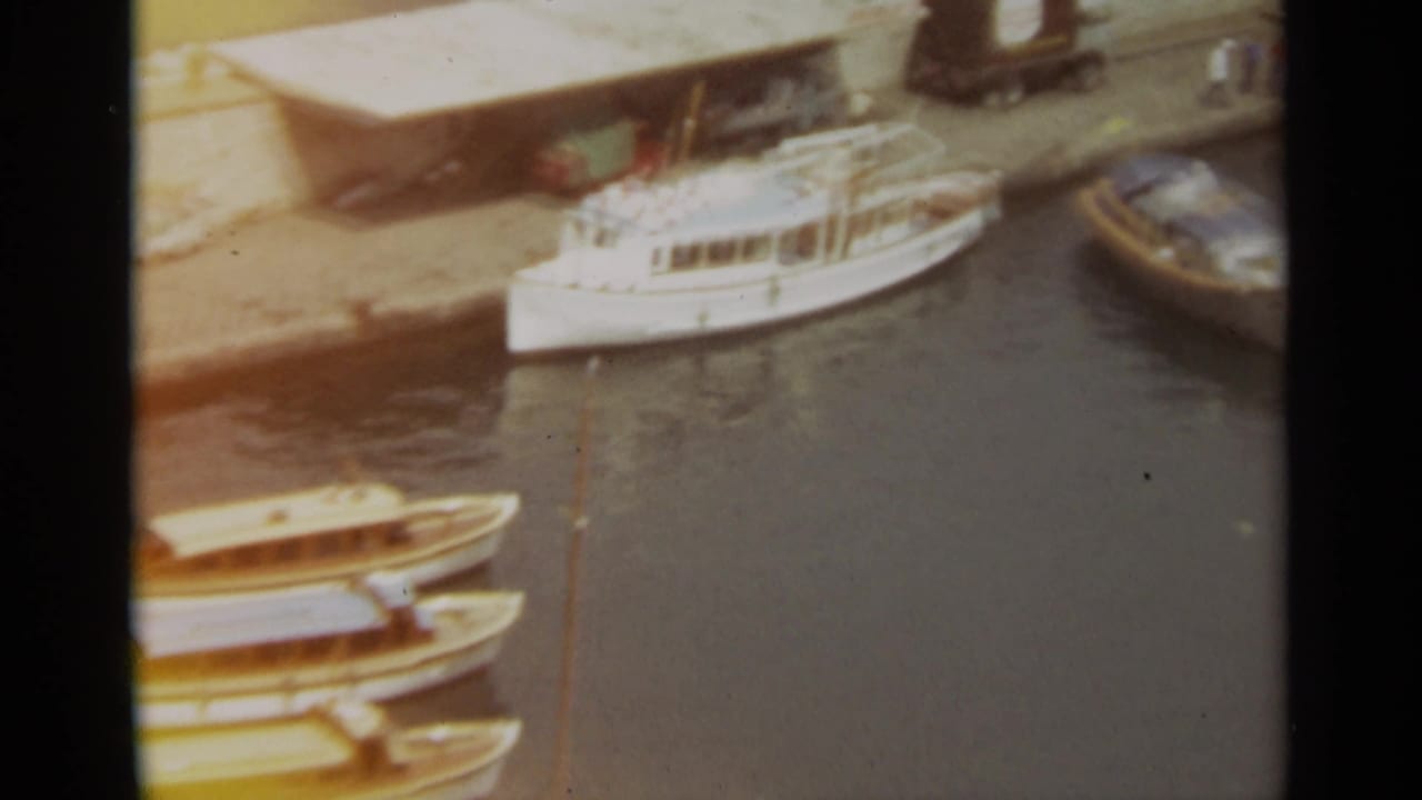 Cabin boats docked along a quay with harbor water beside them.