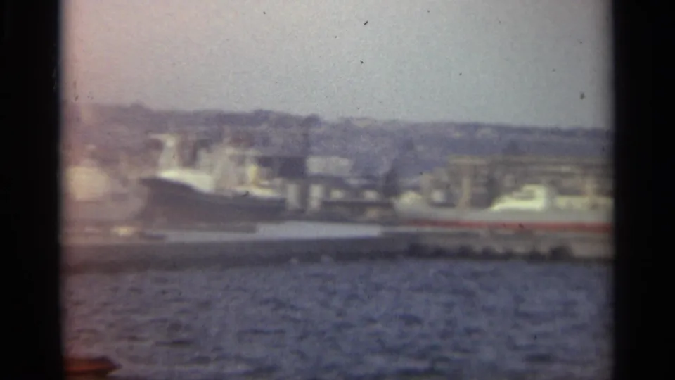 Stockholm waterfront in 1965, showing a large docked ship, harbor water, and dense buildings beyond the quay.