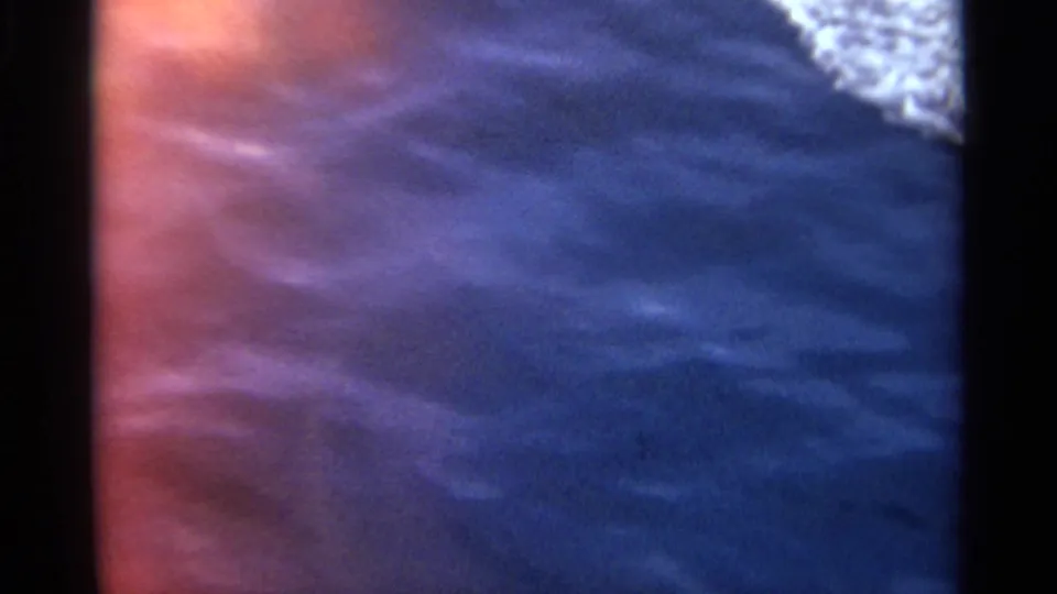 The camera moves off the passenger deck to blue water beside the boat, with a small edge of vessel visible.