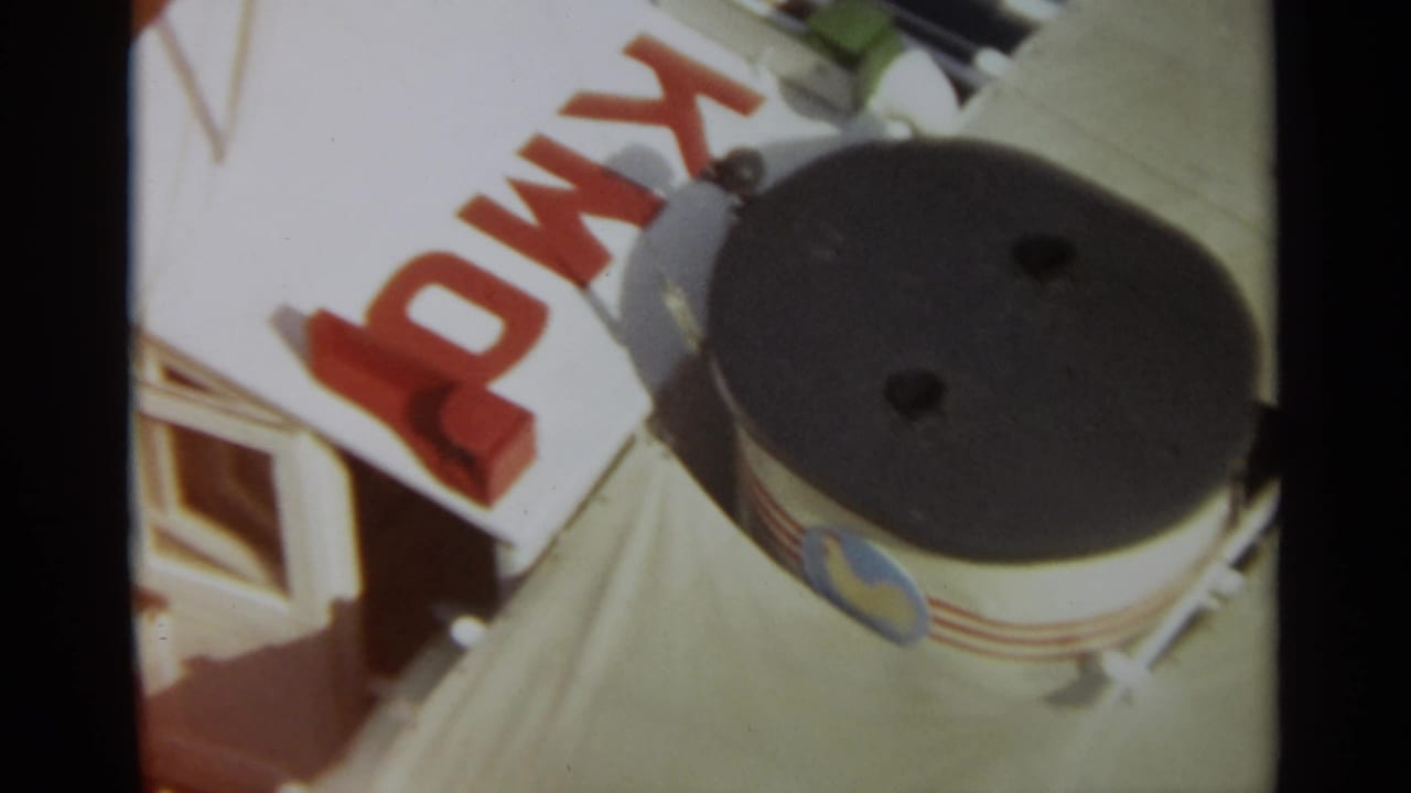 1965 8mm view in Stockholm showing a ship deck surface, red painted lettering, and a cylindrical deck fitting from above.