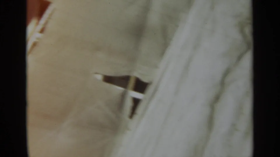 Soft 8mm frame of a pale ship deck in Stockholm, with a small metal fitting or railing detail at the edge.