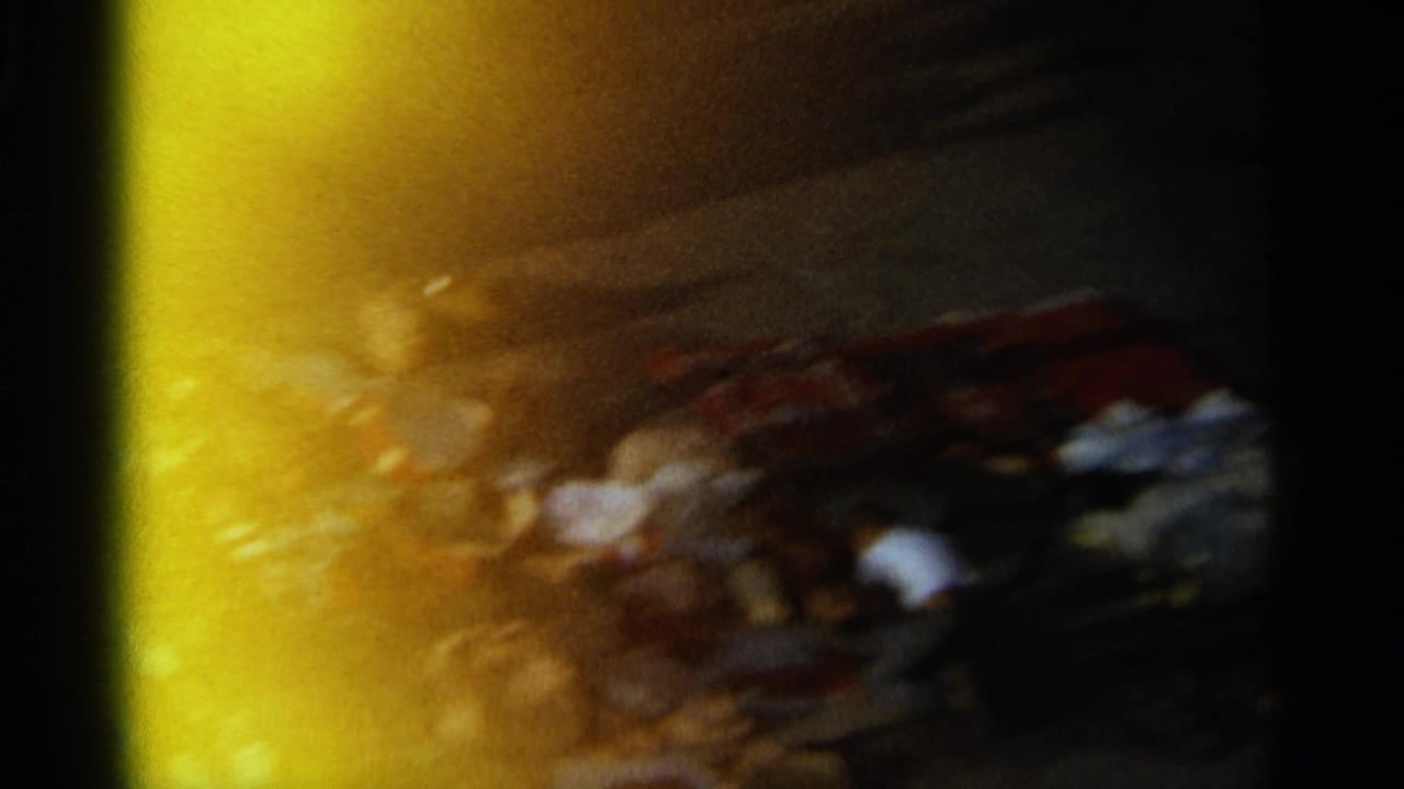 Blurred market scene with strong yellow flare and people near goods.