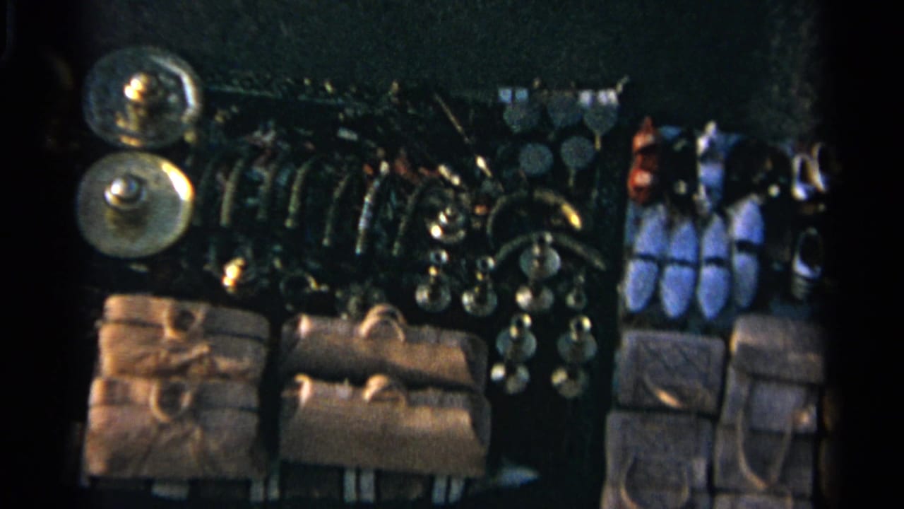 1965 Tangier market stall display with leather bags, slippers, hanging ornaments and shiny metal goods in soft 8mm color.