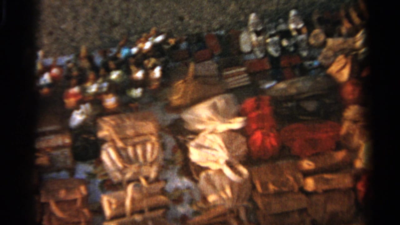 Soft 8mm frame of a Tangier stall with leather bags in front, pale slippers near center and colorful merchandise behind.