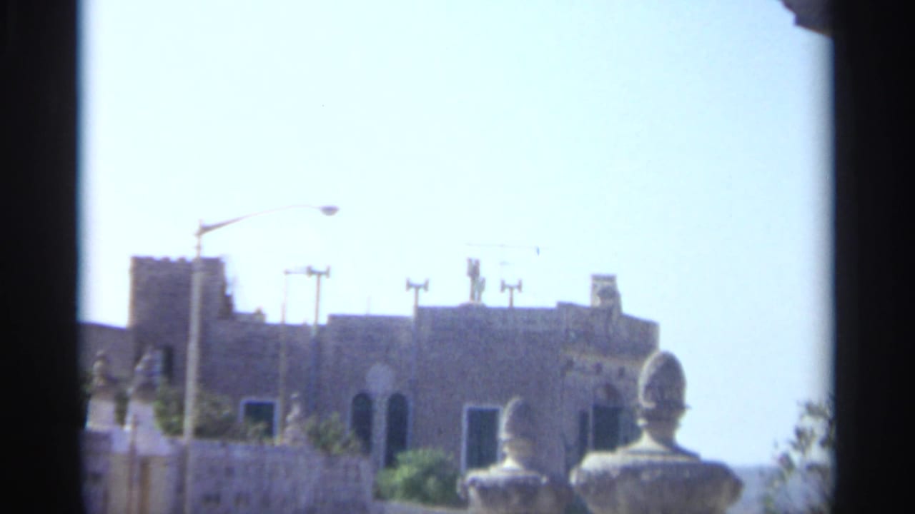Sunlit Tangier exterior showing classical-style stone balustrades and a distant building under a bright sky in 1965 8mm footage.