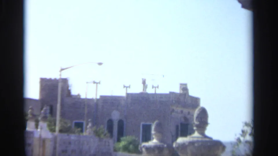 Sunlit Tangier exterior showing classical-style stone balustrades and a distant building under a bright sky in 1965 8mm footage.