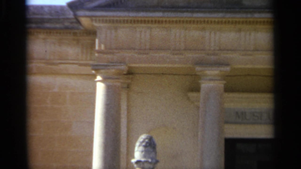 1965 Tangier frame showing columns, carved trim, an entrance bay, and a partial museum sign on the stone building exterior.