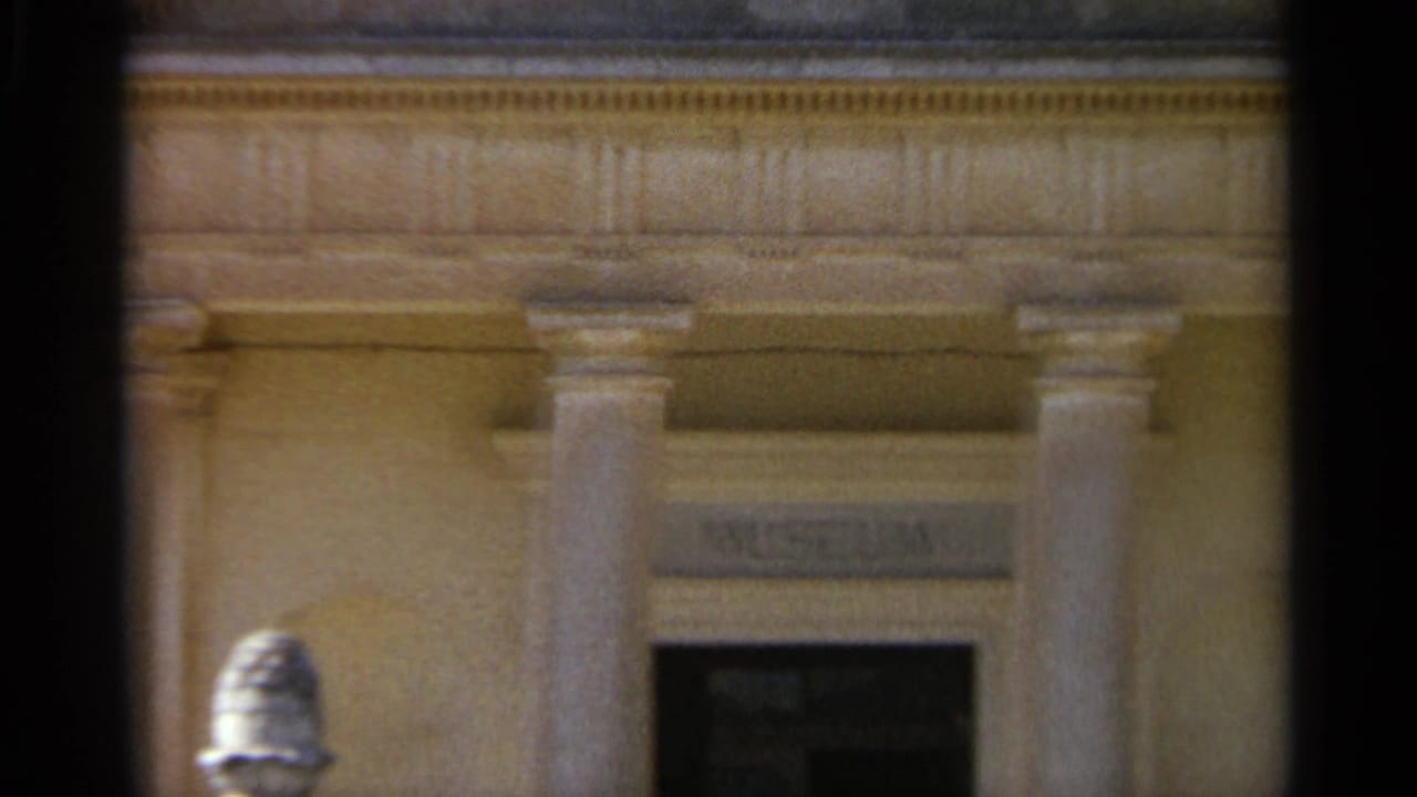 Classical museum entrance with columns and a dark doorway, partly obscured by the contact-sheet edge.