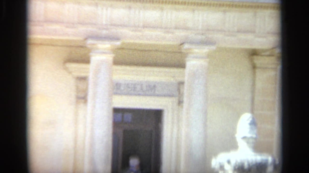 In the Tangier museum exterior, a man is faintly visible in the doorway while columns and a bright foreground fountain or urn frame the view.