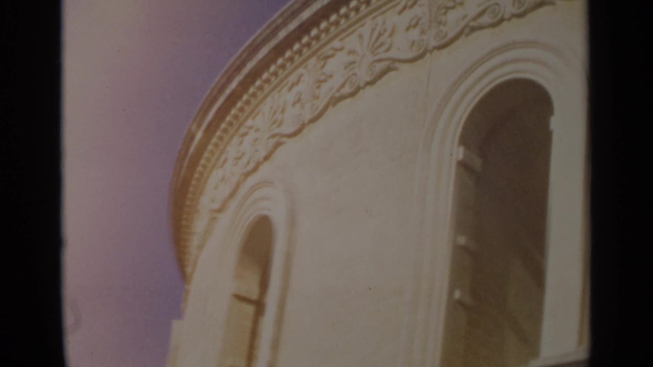 1965 Tangier frame showing a pale curved facade with carved trim and tall arched openings in warm 8mm color.