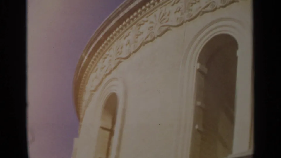 1965 Tangier frame showing a pale curved facade with carved trim and tall arched openings in warm 8mm color.