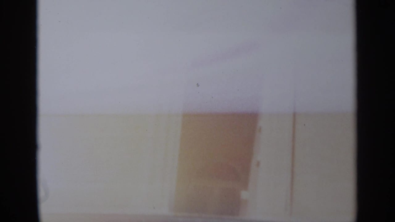 Soft, overexposed 1965 Tangier frame showing pale architectural surfaces and a faint arched opening.
