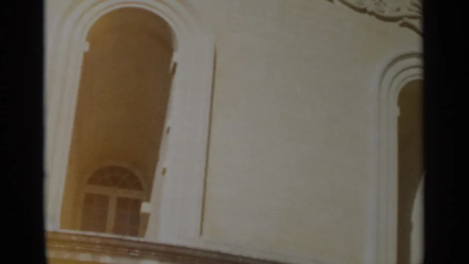 1965 Tangier frame showing an arched window, pale ornate wall, balcony edge and decorative trim near the frame corner.
