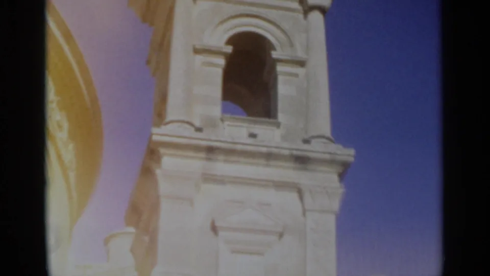 1965 Tangier home-movie view of the church bell tower facade, showing an arched opening, column details and blue sky.