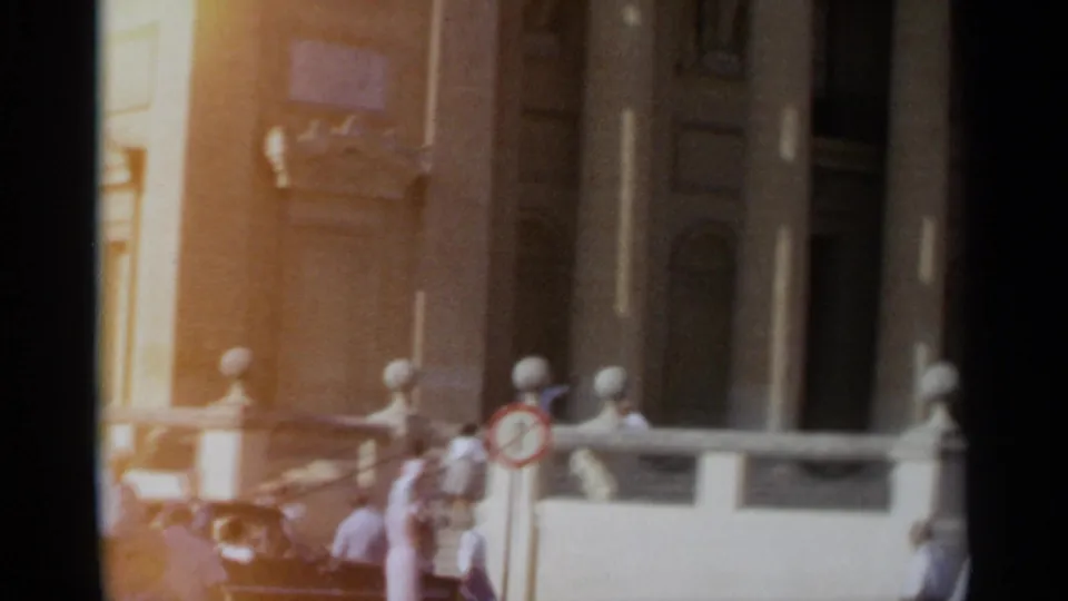 1965 Tangier frame showing the church entrance area with columns, stone bollards and several distant people near the doorway.