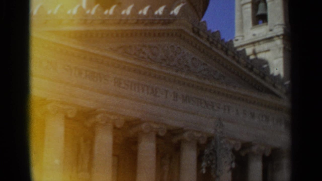 1965 Tangier frame holding on the classical facade, with columns, carved ornament, and visible Latin inscription.